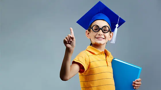 Picture of a child hold wearing a graduation hat and pointing up