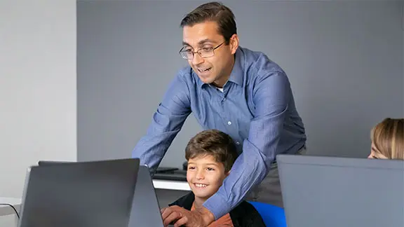 Picture of an instructor helping a student on a laptop