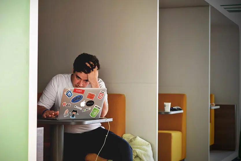 Young man at laptop, youth with stickers on laptop