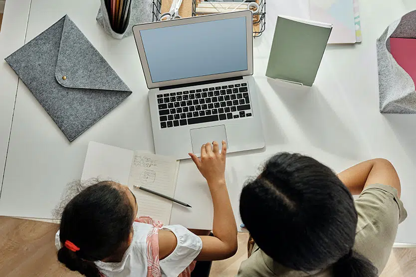 young daughter with mom in front of laptop, seen from above