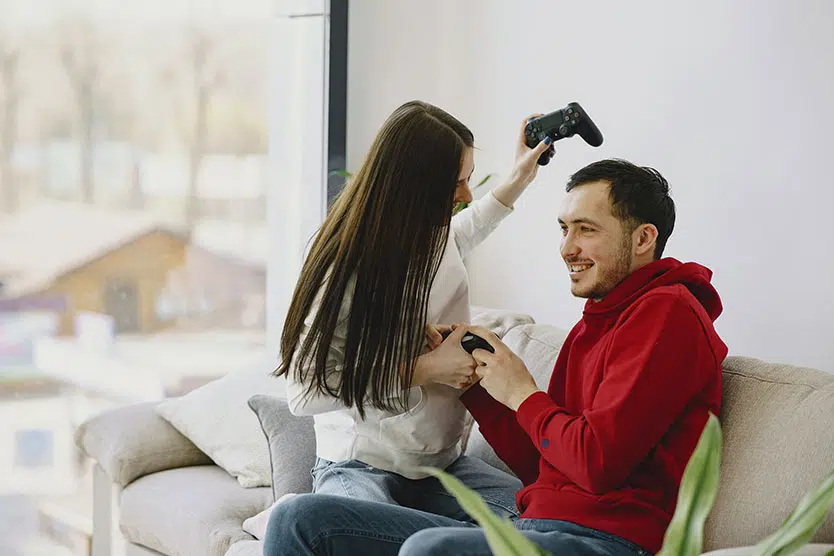 teenagers smiling, video game controllers in hand