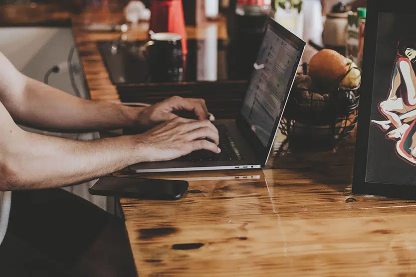 man using laptop, close up only showing hands and arms