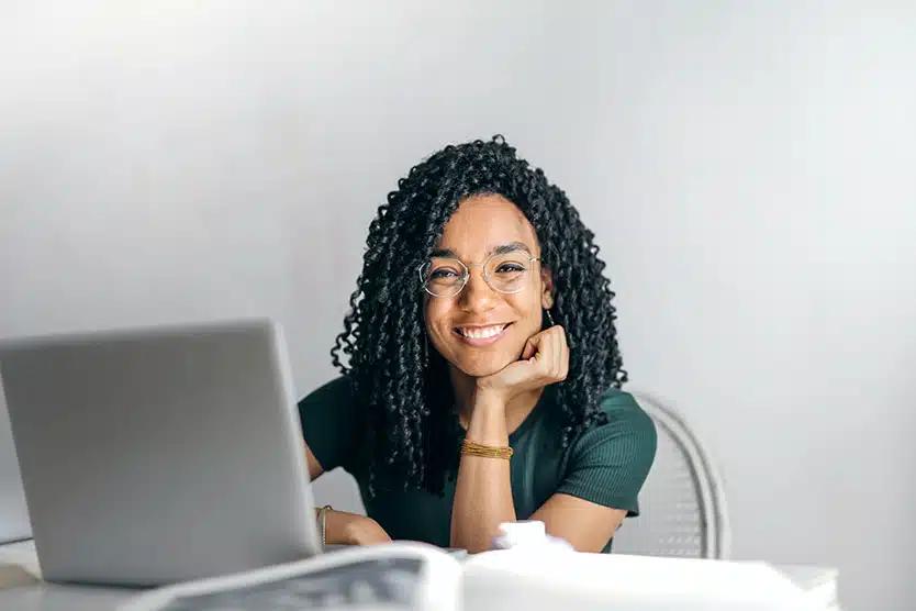girl smiling behind a laptop