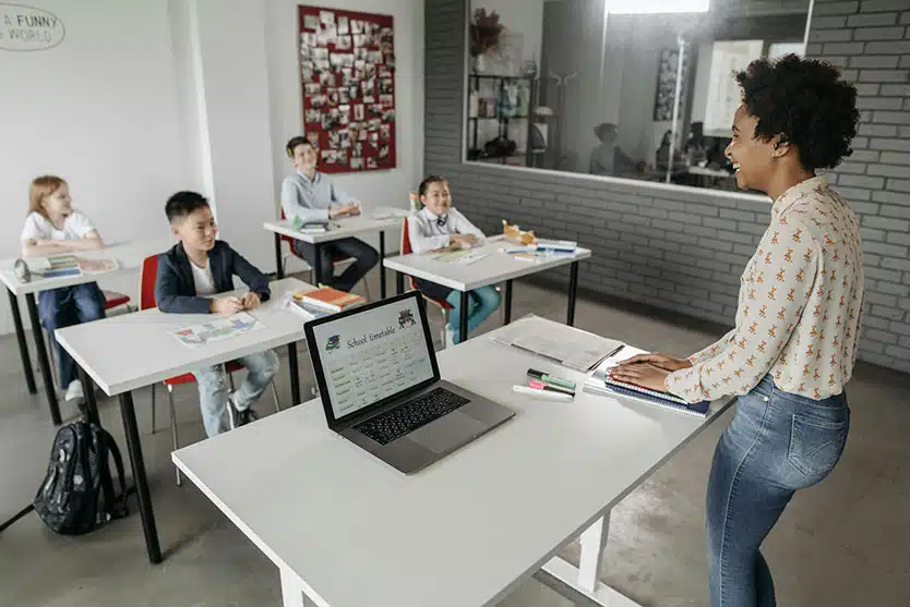 teacher instructs kids in computers