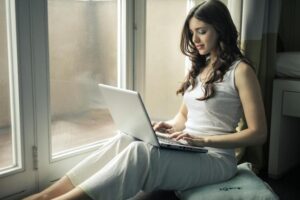 girl with a laptop on a windowsill