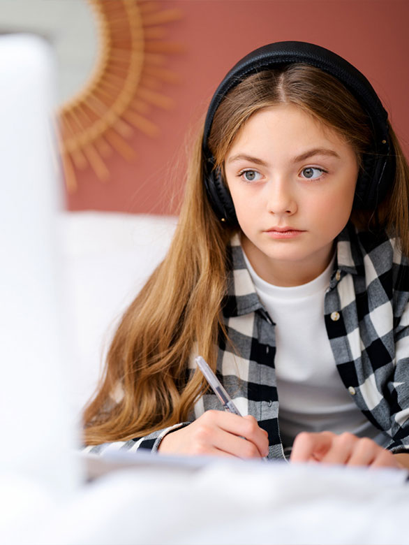 Schoolgirl studying at home using laptop