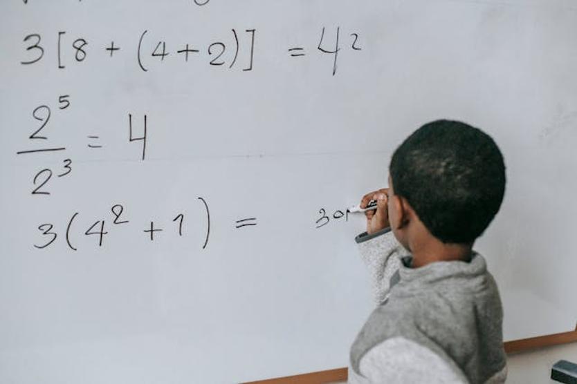 boy doing sums on a whiteboard