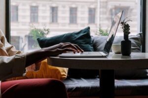 close up of hands using a laptop at a desk