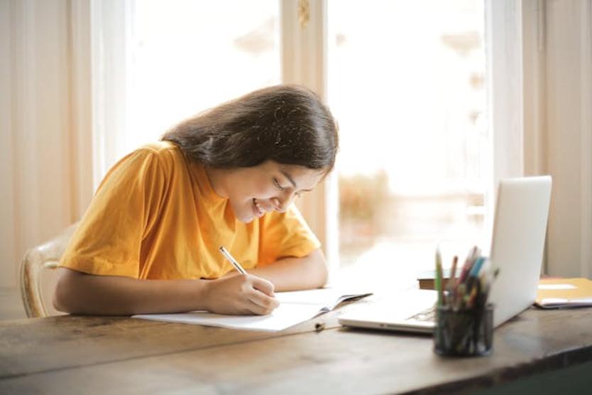 girl using a laptop to do homework