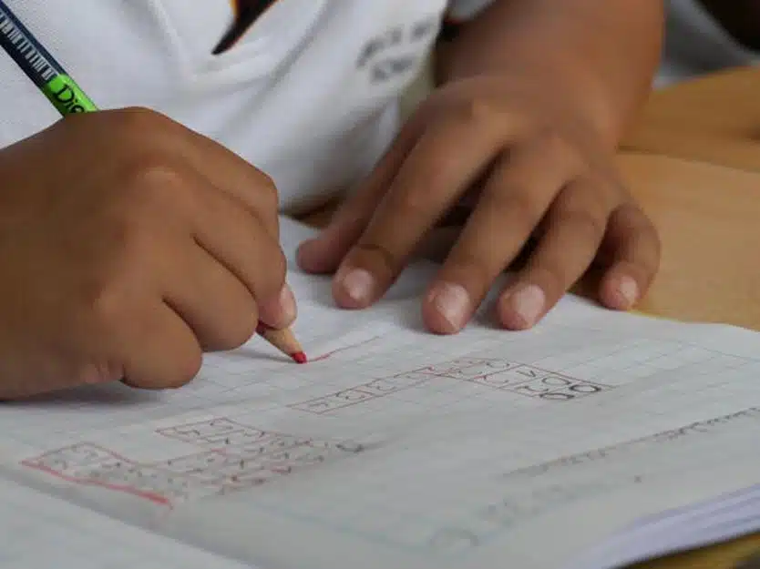 close-up of a child writing math and problem-solving homework